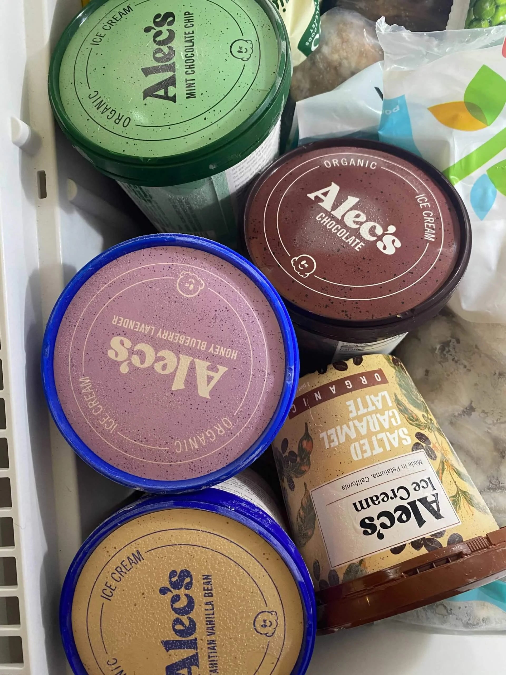 Collection of Alec's ice cream containers and packaging on a white surface.