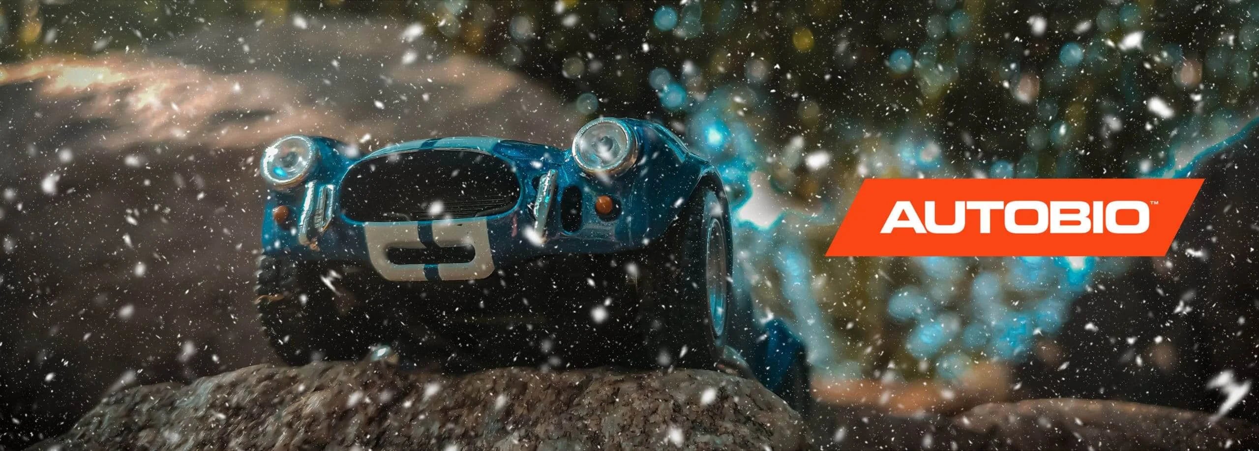 Toy car on a rock with snowfall effect and Autobio logo