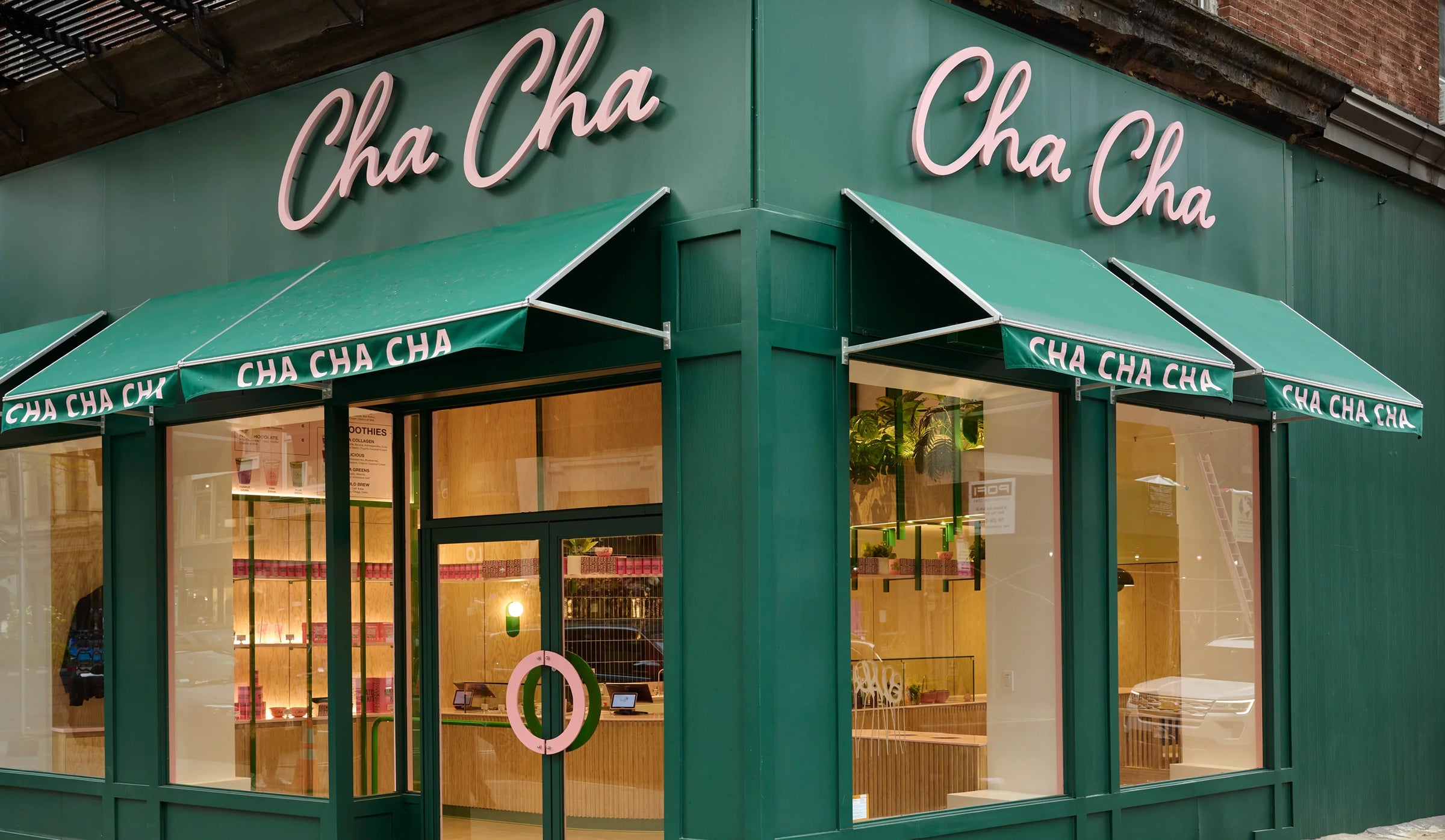 Green storefront with 'Cha Cha' branding on awnings and signage.