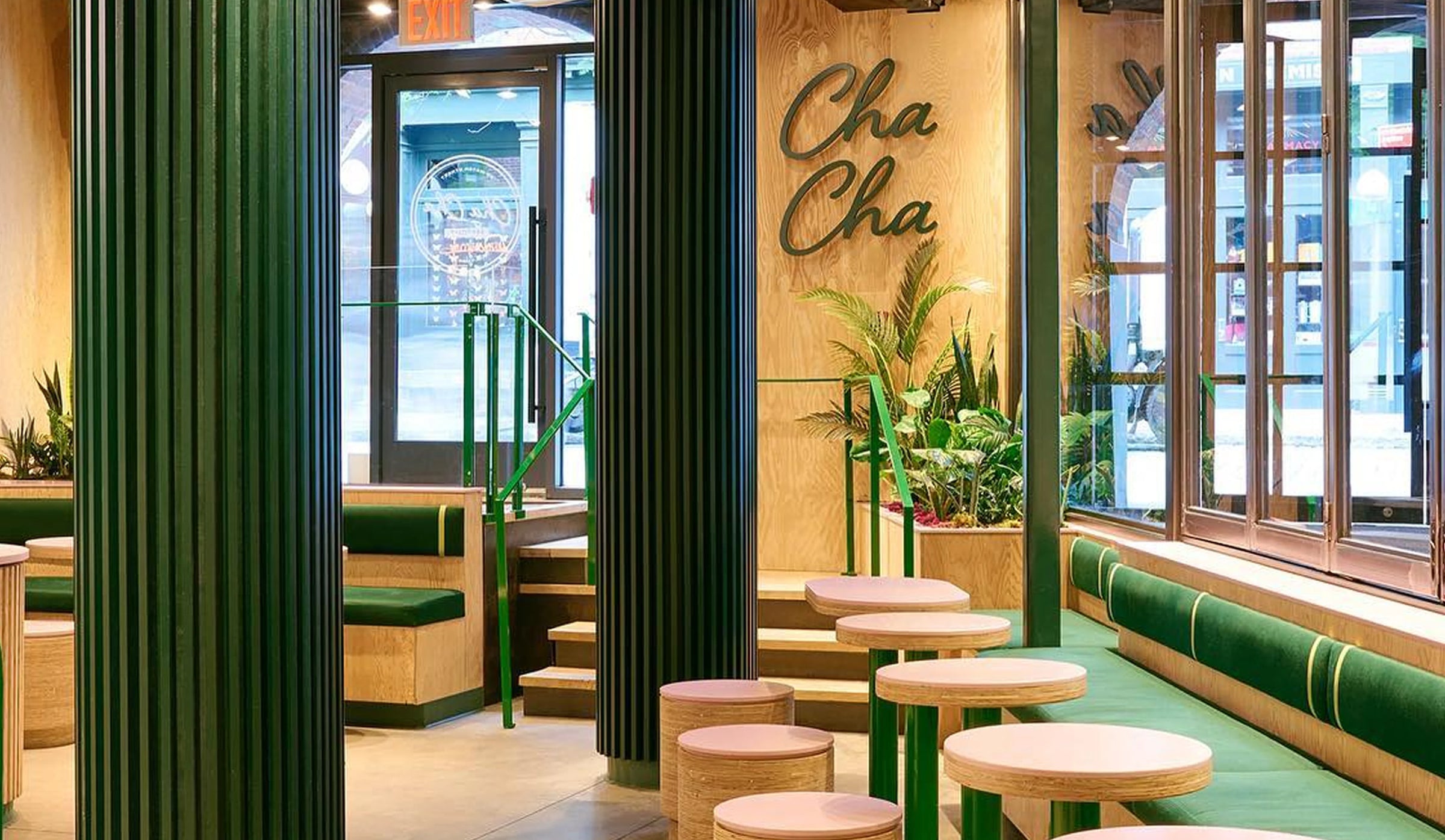 Modern interior of a restaurant with green and beige decor, featuring the brand 'Cha Cha'.