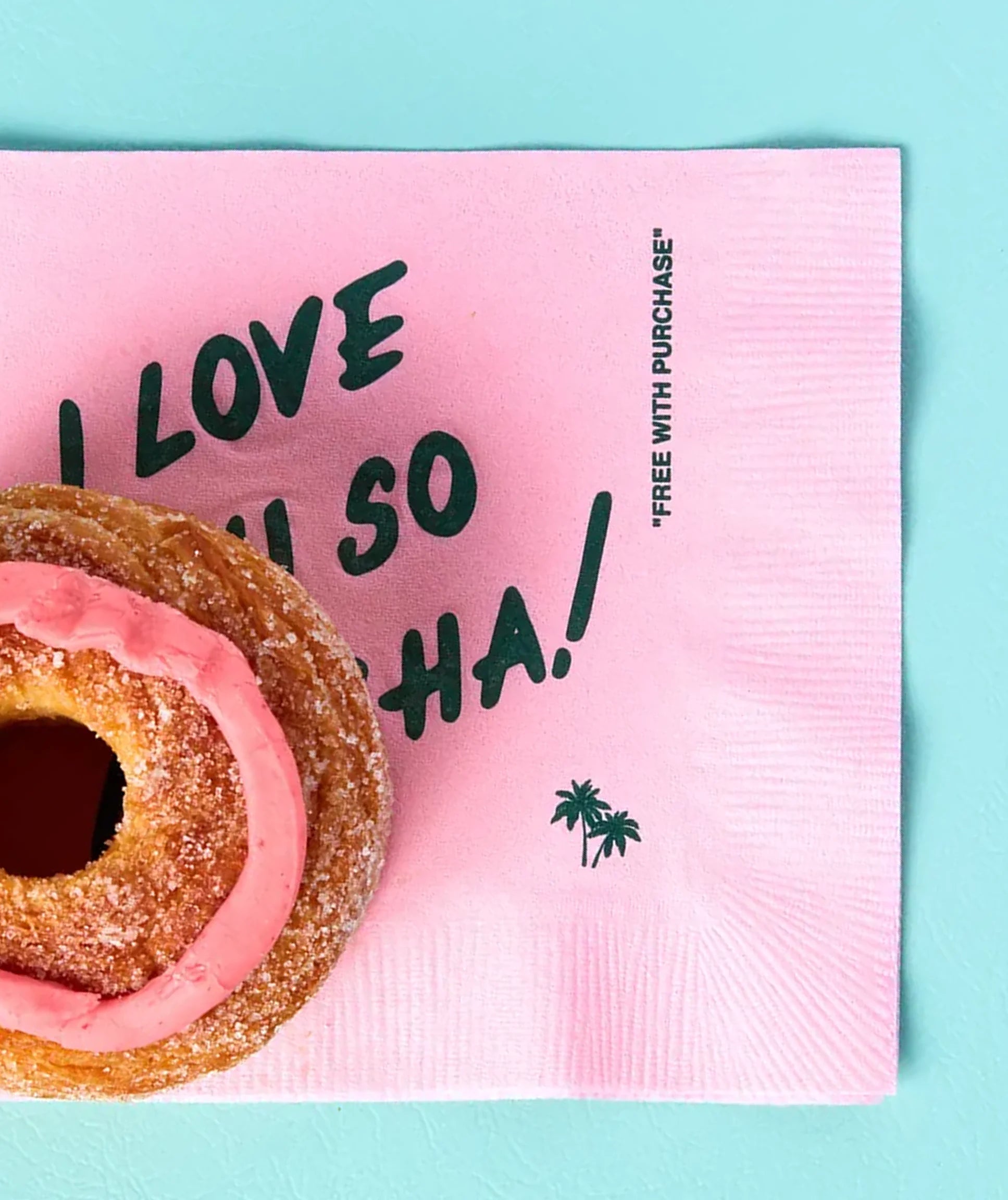 Pink napkin with text and a donut on a light blue background