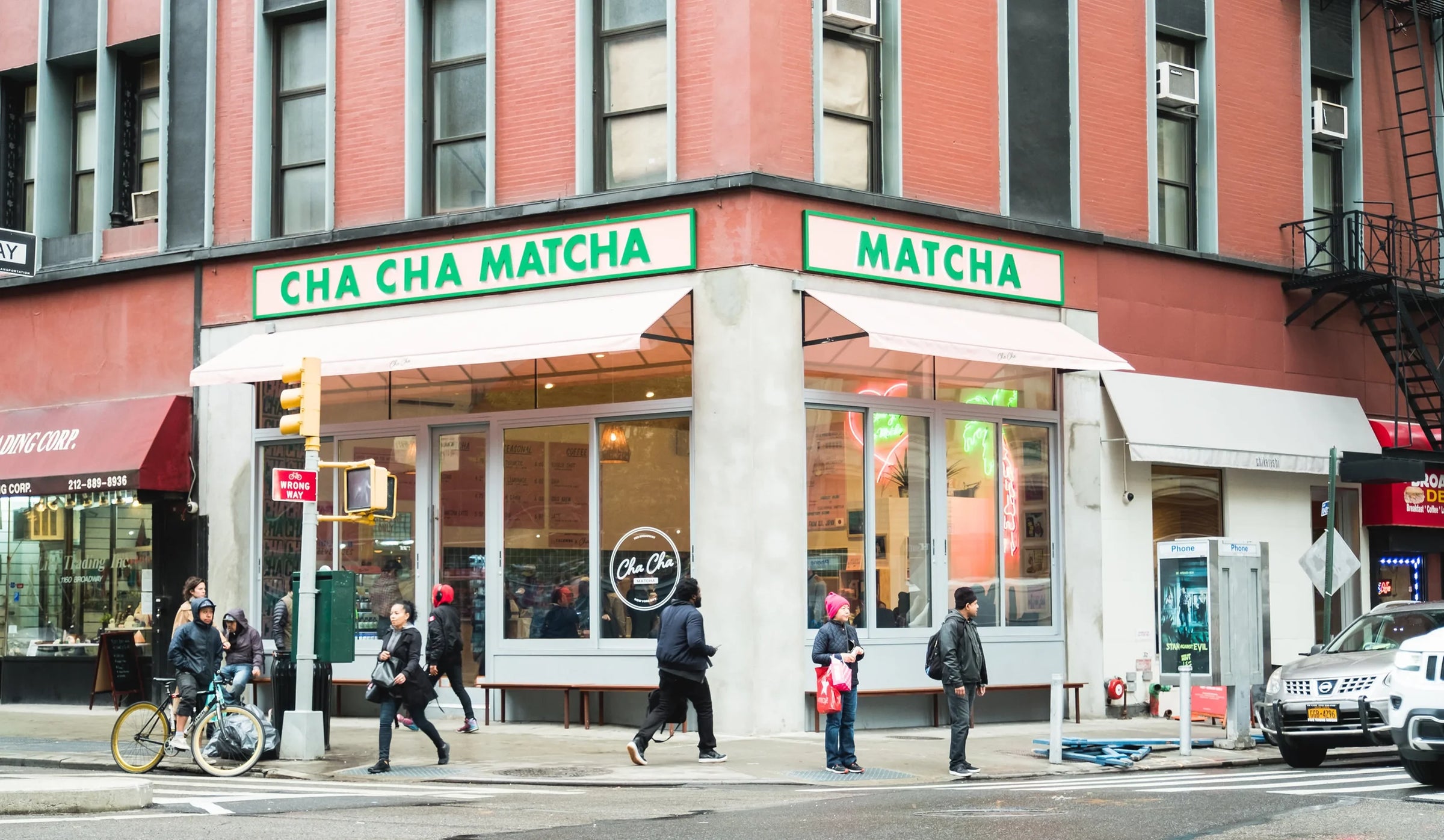 Cha Cha Matcha store front on a city street with pedestrians and traffic.