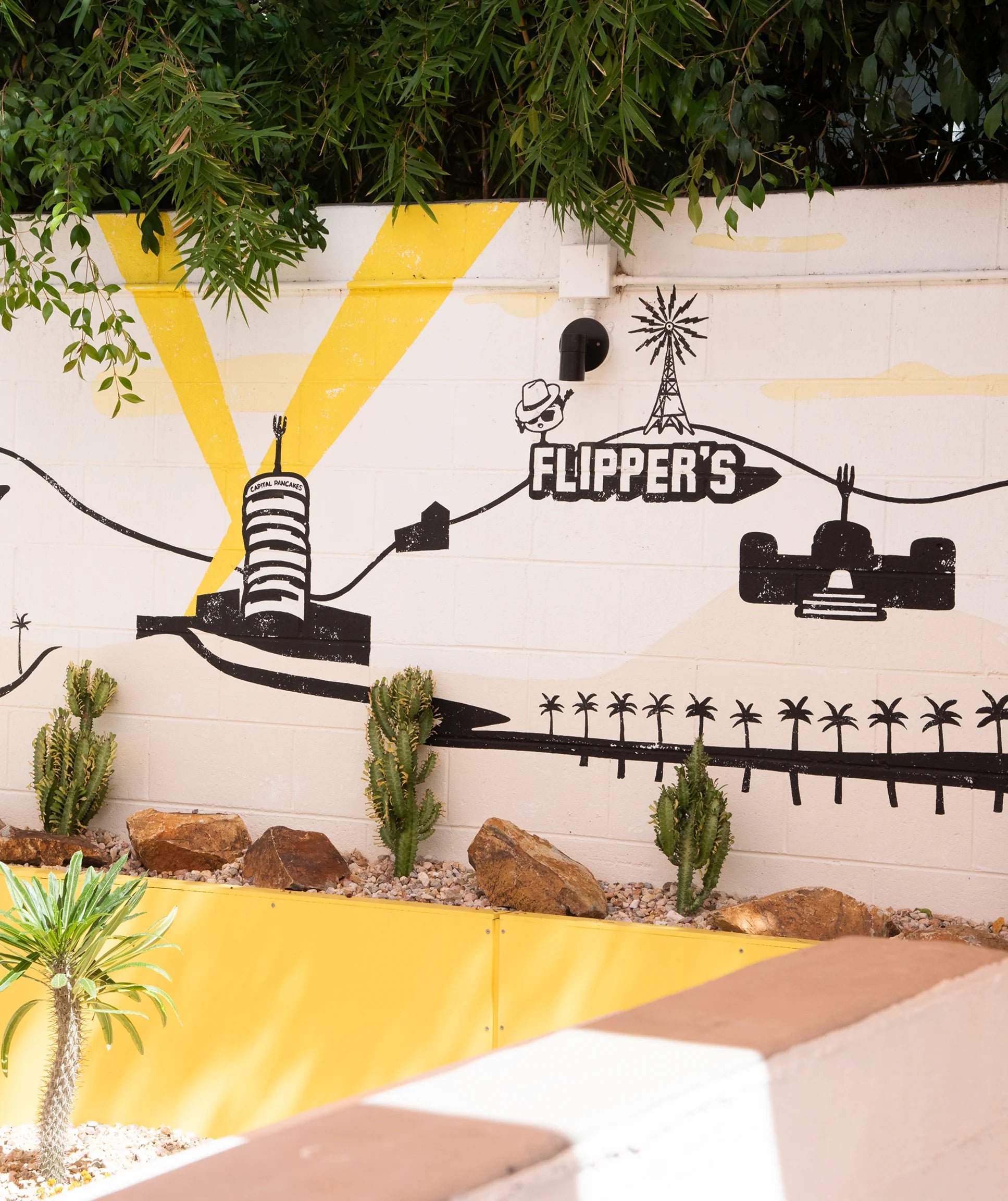 Mural with 'Flipper's' branding on a wall with decorative elements and plants.