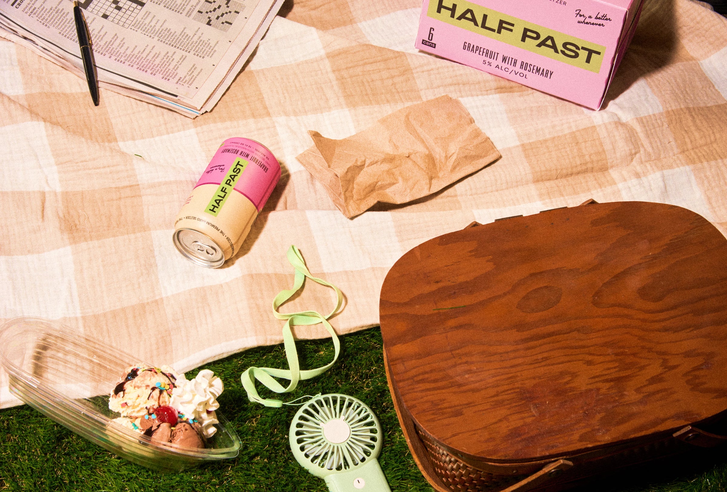 Table with a can, sunglasses, and a box on a checkered tablecloth