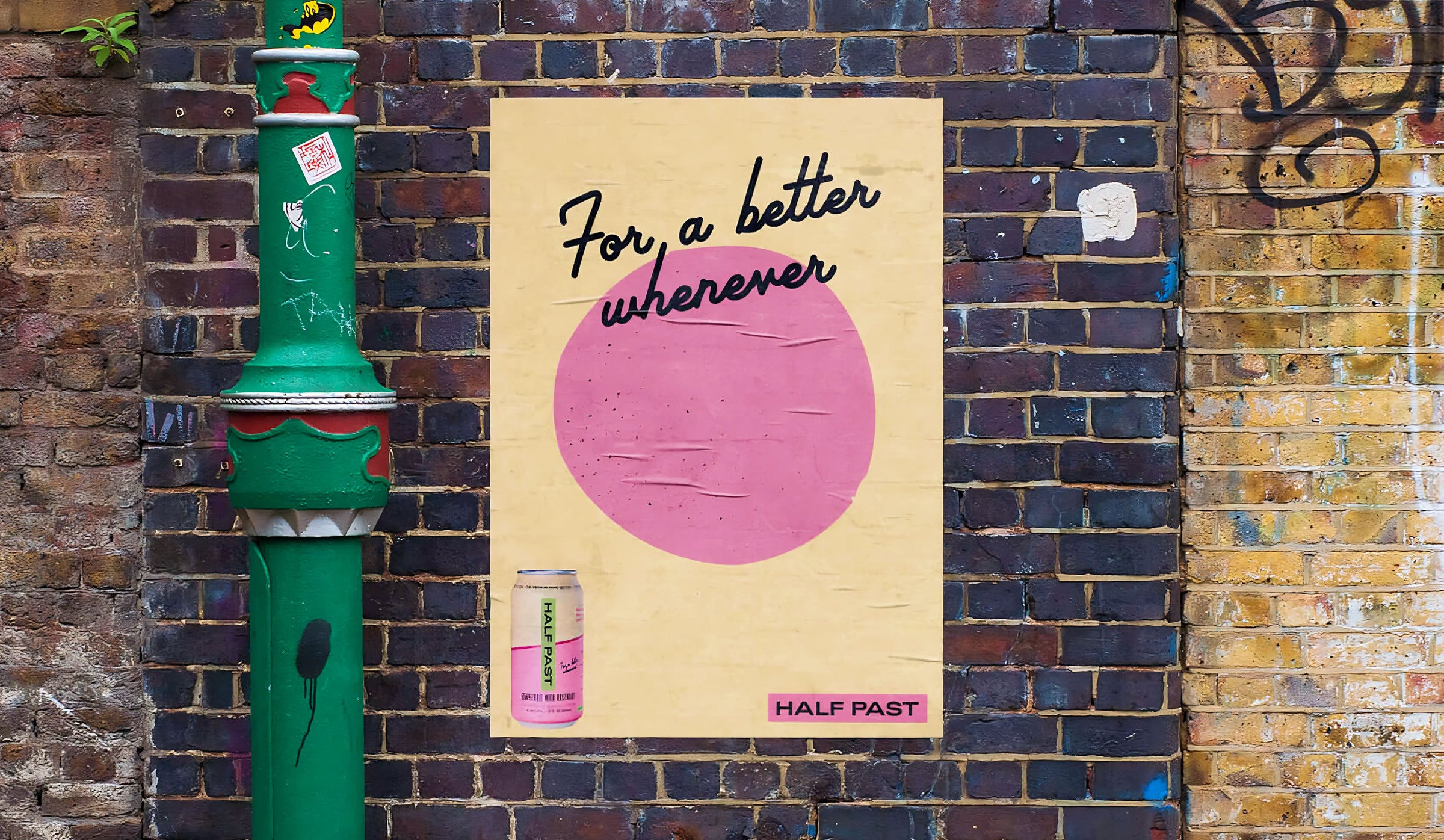 Poster with text and pink circle on a brick wall next to a green pole.