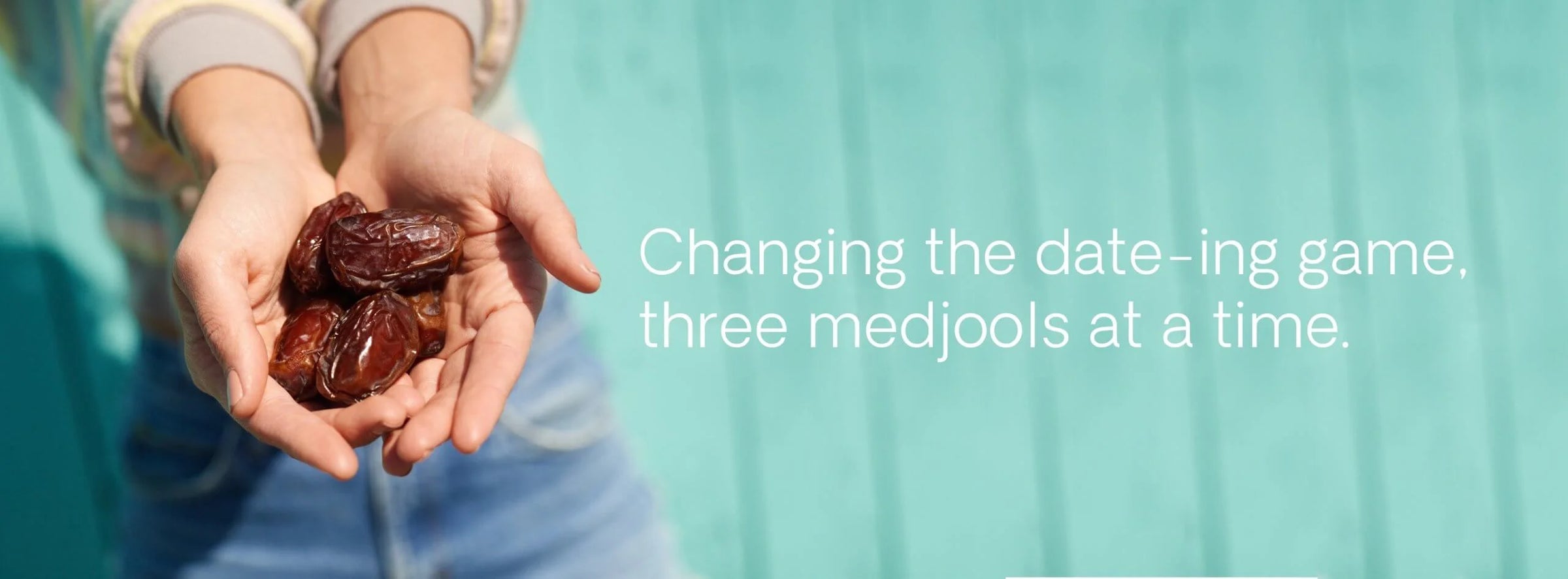 Hands holding dates with text 'Changing the date-ing game, three medjools at a time.' on a teal background
