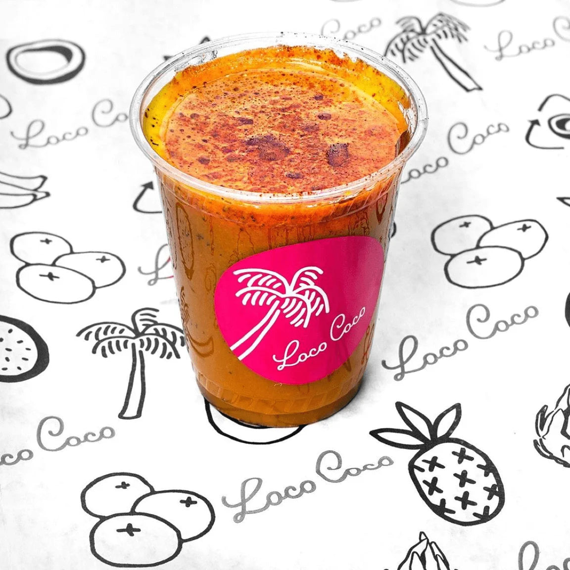 Clear plastic cup with a colorful drink on a branded background