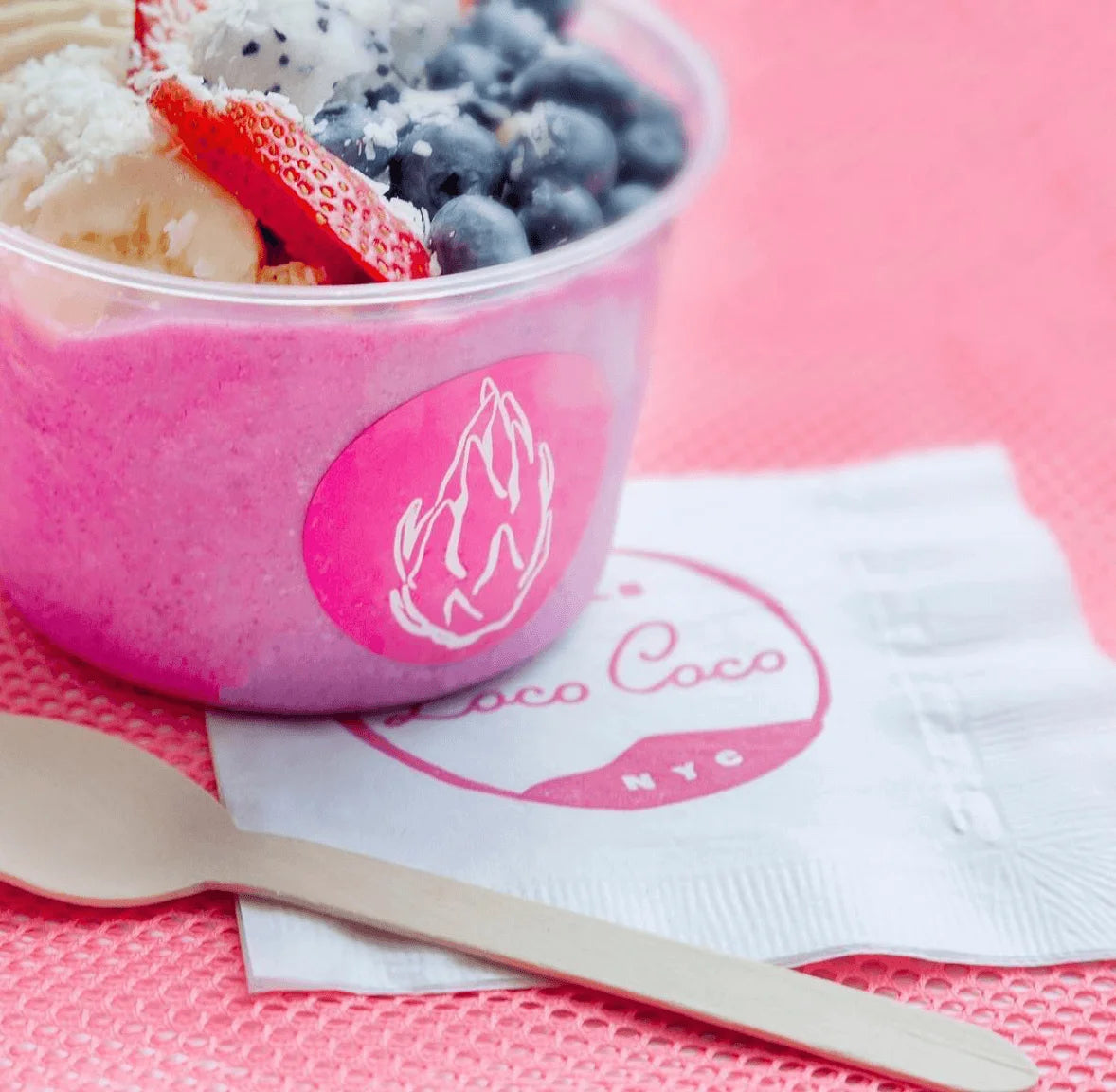 Pink bowl of ice cream with berries on a pink background, featuring the 'Loco Coco' logo.