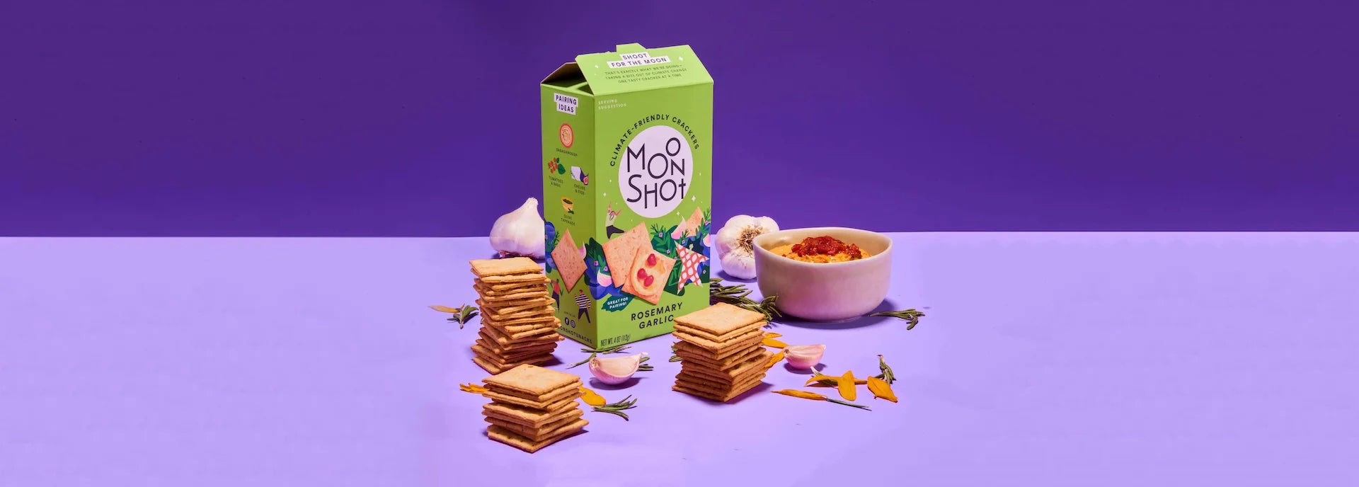 Moon Shot Rosemary Garlic snacks with a green box on a purple background.