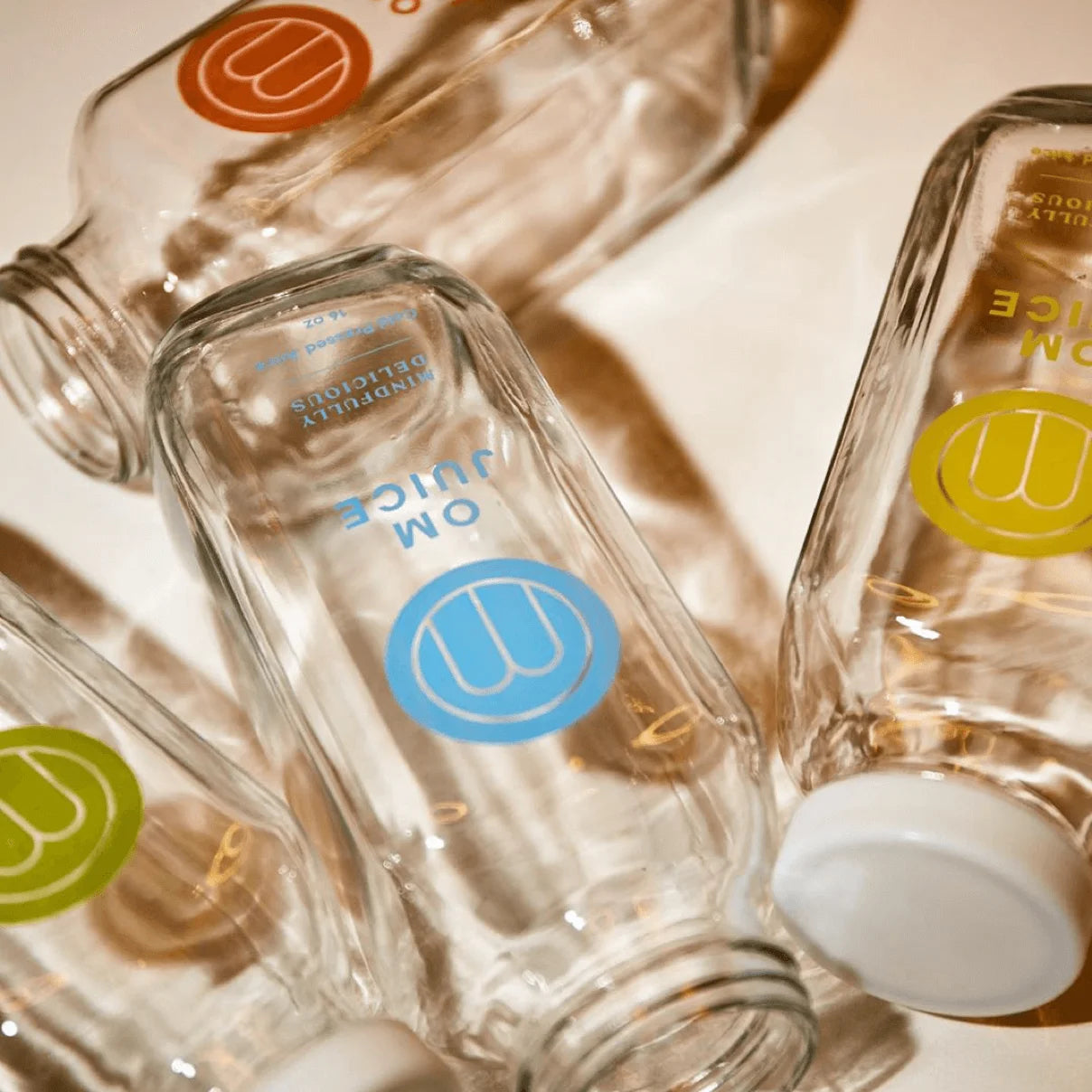 Clear glass bottles with colorful labels on a reflective surface