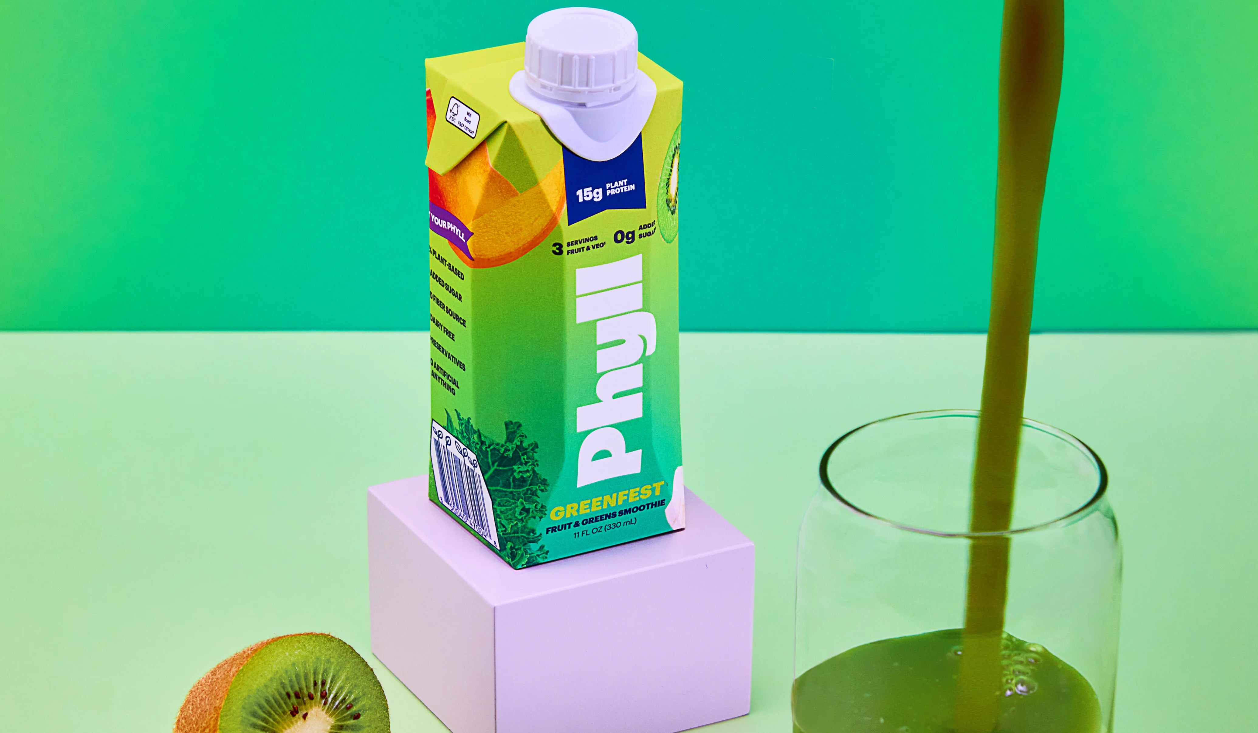 Carton of Phyllo Green Tea with a glass being filled on a green background